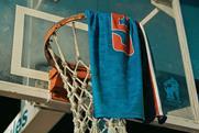 blue-towel-with-number-5-hangs-on-basketball-hoop