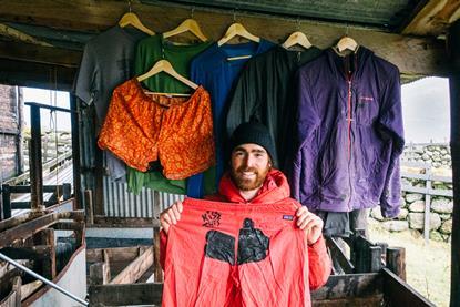 A man holding repaired pants by Patagonia