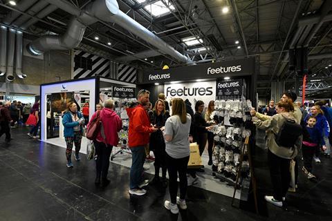 Visitors browse products and talk with exhibitors at the Feetures booth during IRX.