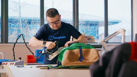 A worker from Berghaus' Repairhaus repairs outdoor clothing and equipment